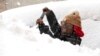 Zaria Black, 24, , clears off her car as snow falls in Buffalo, N.Y. 