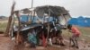 Sudanese people, who fled the conflict in Sudan's Darfur region, sit at their makeshift shelter during a rainstorm at a refugee camp in Ourang on the outskirts of Adre, Chad, July 30, 2023.