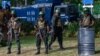 Army soldiers stand guard during a protest by Sri Lankan rights activists outside the main cemetery in Colombo, July 23, 2023. Sri Lanka tightened security Sunday as activists lit lamps in Colombo to honor hundreds killed in 1983 anti-Tamil riots.