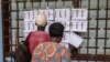 Voters check for their names on the voters roll at the Boganda high school in Bangui, on July 30, 2023.