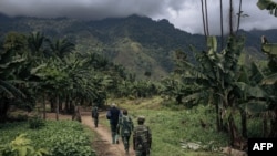Sejumlah tentara Kongo terlihat berpatroli di desa Mwenda, yang baru diserang oleh kelompok pemberontak ADF, pada 23 Mei 2021. (Foto: AFP/Alexis Huguet)