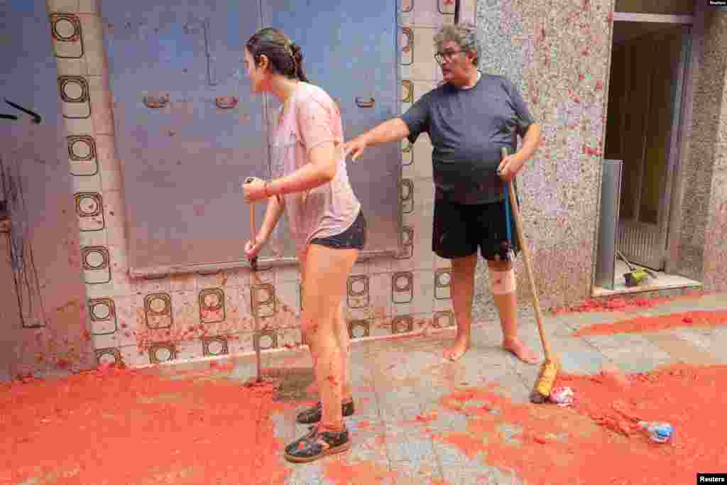 Residentes locales limpian pulpa de tomate después del festival anual de peleas de comida 'La Tomatina' en Buñol, cerca de Valencia, España, el 28 de agosto de 2024.