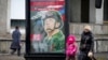 People walk past an army recruitment billboard with the words "Military service under contract in the armed forces," in St. Petersburg, Russia, March 24, 2023.
