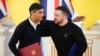 Perdana Menteri Inggris Rishi Sunak, kiri, memeluk Presiden Ukraina Volodymyr Zelenskyy setelah menandatangani dokumen di Kyiv, Ukraina, 12 Januari 2024. (Foto: AP)