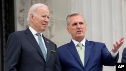 Presiden Joe Biden berbicara dengan Ketua DPR Kevin McCarthy dari California, di tangga DPR saat perayaan Hari St. Patrick di Capitol di Washington, Jumat, 17 Maret 2023. (Foto: AP)