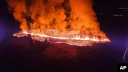 Foto yang diambil dari atas helikopter ini menunjukkan aliran lava yang keluar setelah gunung berapi di dekat Kota Grindavík, Islandia, meletus, pada 14 Januari 2024. 