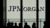 FILE - People are silhouetted under a JPMorgan Chase & Co. logo at the bank's headquarters in New York City, Oct. 21, 2013.