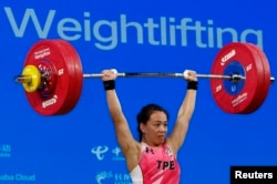 Kuo Hsing Chun dari Taipei beraksi pada kejuaraan angkat besi putri Grup A kelas 59 kilogram, pada ASIAN Games di Xiaoshan Sports Center Gymnasium, Hangzhou, China, 2 Oktober 2023. (REUTERS/Kim Kyung-Hoon)