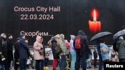 Orang-orang mengantre untuk menaruh bunga di lokasi dekat Balai Kota Crocus, tempat di mana lebih dari 130 orang tewas terbunuh dalam serangan teroris, di Moskow, Rusia, pada 24 Maret 2024. (Foto: Reuters/Maxim Shemetov)