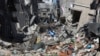Seorang warga Palestina berjalan melewati bangunan-bangunan yang hancur akibat serangan Israel di Khan Younis, Jalur Gaza, 8 Maret 2024. (Foto: AP)