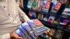 Seorang pria membawa salinan buku 'The Conspiracy' yang ditulis oleh presiden terguling Sri Lanka Gotabaya Rajapaksa di sebuah toko buku di Kolombo, 7 Maret 2024. (Ishara S.KODIKARA/AFP)