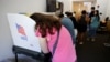 A voter leans into the booth while casting her ballot on the last day of the state's early voting for the 2022 midterm elections in Chapel Hill, North Carolina, Nov. 5, 2022.