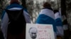 Russians with the Russian anti-war flags wrapped around them, take part in a protest against the Russian invasion of Ukraine in front of the Russian embassy in Vilnius, Lithuania, March 12, 2022. 