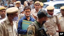 কাশ্মীরি বিচ্ছিন্নতাবাদী নেতা ইয়াসিন মালিককে পুলিশ অফিসাররা ভারতের নয়াদিল্লিতে একটি আদালতে নিয়ে যাচ্ছে। ২৫ মে ২০২২। (ছবি-এপি/দীনেশ যোশী)