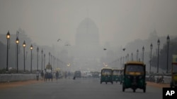 India's Rashtrapati Bhawan, or the Presidential Palace is partly visible due to smog as traffic plies on Rajapth, the ceremonial boulevard in New Delhi, India, Nov. 1, 2018.