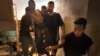 Syrian rebels carry a wounded comrade into a secret field hospital in al-Bab, August 10, 2012.