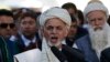 FILE - Afghanistan's President Ashraf Ghani (C) talks with the media after Eid al-Adha prayers at the presidential palace in Kabul.