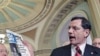 Sen. John Barrasso [C] quotes a USA Today article about gas prices as he and Sen. Lamar Alexander [L] and Senate Republican leader Mitch McConnell [R] speak to reporters, at the Capitol in Washington, D.C., May 17, 2011