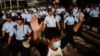 A protester raises his arms as police officers try to disperse a crowd near government headquarters in Hong Kong, Sept. 29, 2014.