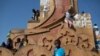 Crianças brincam num monumento em Bissau