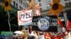 FILE - Climate change activists carry signs as they march during a protest in Philadelphia a day before the start of the Democratic National Convention, July 24, 2016.