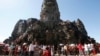 In this Sunday, Dec. 31, 2017, photo, tourists line up for stepping up Angkor Wat temple outside Siem Reap, Cambodia. Tourists celebrated New Year at Angkor Wat temple where is Cambodia's main tourist destination. The temples, built between the 9th and 15th centuries. (AP Photo/Heng Sinith)