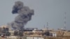 File - A plume of smoke rises above a building after an airstrike by the U.S.-led coalition battling the Islamic State group, in Tikrit, Iraq, March 2015. 
