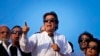 FILE - Pakistan's cricketer-turned-politician Imran Khan, center, is surrounded by aides as he addresses to his supporters near the parliament building in Islamabad, Pakistan, Aug. 27, 2014. 