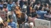 A demonstrator holds a burning placard with a picture of Syria's President Bashar al-Assad after Friday prayers in Talbiseh, near Homs, April 20, 2012. The sign on the right reads 'No to medicines; yes to freedom.'