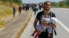 A Syrian migrant carries a baby as he walks towards the Greece border on a road near Edirne, Turkey, Sept. 15, 2015. 