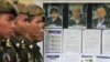 Cambodian military officials line up in front the top leaders of Khmer Rouge portraits, from right, former Khmer Rouge Foreign Minister Ieng Sary, former Khmer Rouge head of state Khieu Samphan, and former Deputy Secretary Nuon Chea, during the second d