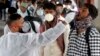 একজন স্বাস্থ্যকর্মী একটি ট্রেন স্টেশনে শহরে প্রবেশের অনুমতি দেয়ার আগে একজন ভ্রমণকারীর কাছ থেকে কোভিড-১৯ পরীক্ষা করার জন্য নমুনা সংগ্রহ করছেন। ১২ জানুয়ারী ২০২২। (ছবি-এপি/রাজনীশ কাকড়ে)