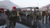 Afghan soldiers stand around a damaged bus at the site of a suicide attack by the Taliban in Kabul, Dec. 13, 2014. 