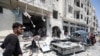 FILE - Syrians gather at a site of car bomb in the northwestern Syrian city of Idlib, Aug. 2, 2018. U.N. reports an upsurge in aerial and ground-based bombardment by Syrian and Russian forces over the past week has killed scores of civilians and displaced more than 30,000 women, children and men within the region.