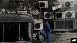 Penyelidik memeriksa lokasi kebakaran di sebuah rumah sakit di Beijing, Rabu, 19 April 2023. (AP/Andy Wong)