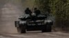 Prajurit Ukraina menaiki sebuah tank di jalan menuju kota garis depan Bakhmut, di tengah serangan Rusia di Ukraina, di wilayah Donetsk, Ukraina Jumat 12 Mei 2023.