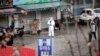 FILE - A worker in a protective suit is seen at a shuttered seafood market during the early spread of the coronavirus, in Wuhan, Hubei province, China Jan. 10, 2020.