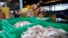 Migrant workers separate freshly caught fish by size at a fish market in Samut Sakhon Province, west of Bangkok, June 20, 2014.