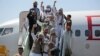 Tahanan Yaman mengepalkan tangan saat tiba di bandara di Sana'a setelah dibebaskan oleh koalisi pimpinan Saudi. (Foto: AP)