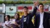 El candidato ganador de las elecciones locales Kelvin Lam, a la derecha, junto al activista prodemocracia Joshua Wong, segundo a la derecha, saludan a la gente y dan gracias por el apoyo en la estación South Horizons de Hong Kong, el lunes de noviembre de 2019. AP/Vincent Yu.