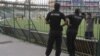 Police watch as members of the Zimbabwe cricket team practice in Gaddafi Stadium in Lahore, Pakistan, May 21, 2015. Pakistan will host Zimbabwe on May 22 after 6 years without hosting international cricket. 