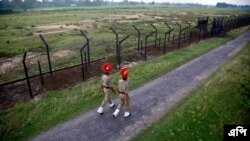 ছবিতে, ভারতীয় সীমান্তরক্ষী বাহিনীর কর্মীরা উত্তর-পূর্ব ভারতের আসাম রাজ্যের ঠাকুরানবাড়ি গ্রামে ভারত-বাংলাদেশ সীমান্তে একটি বেড়ার কাছে টহল দিচ্ছে৷ ২ সেপ্টেম্বর ২০১৬। (ছবই-এপি/অনুপম নাথ)