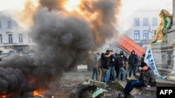 FiLE - Seorang pria duduk di samping patung selama aksi protes petani di distrik Eropa di Brussels, yang diselenggarakan oleh serikat petani umum ABS (Algemeen Boerensyndicaat), 1 Februari 2024. (DIRK WAEM/AFP)