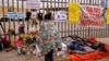 Migran tidur di samping altar di luar pusat penahanan migran di mana beberapa migran meninggal setelah terjadinya kebakaran di Ciudad Juarez, Meksiko, 30 Maret 2023. (REUTERS/Jose Luis Gonzalez)
