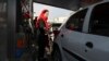Una mujer llena su automóvil en una estación de servicio en Teherán, Irán, el viernes 15 de noviembre de 2019. Las autoridades impusieron el racionamiento y aumentaron los precios del combustible.