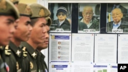 Cambodian military officials line up in front the top leaders of Khmer Rouge portraits, from right, former Khmer Rouge Foreign Minister Ieng Sary, former Khmer Rouge head of state Khieu Samphan, and former Deputy Secretary Nuon Chea, during the second d