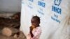 FILE - A girl eats a mango at a shelter for displaced people in Bangui, Central African Republic, April 24, 2017. 