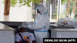 Profissional de saúde faz teste a taxista de Covid-19 no Marco Histórico do Cazenga, Luanda, Angola. 31 agosto 2020