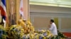 In this photo released by Thai Spokesman Office, Gen. Prayuth Chan-ocha pays a respect to a royal endorsement, black book seen at center, in front of the portrait of King Bhumibol Adulyadej as he accepted the written royal command issued by the King cert