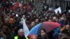 People march under rain during a demonstration in support of migrant people seeking to enter Europe, in Brussels, Saturday, Jan. 12, 2019.